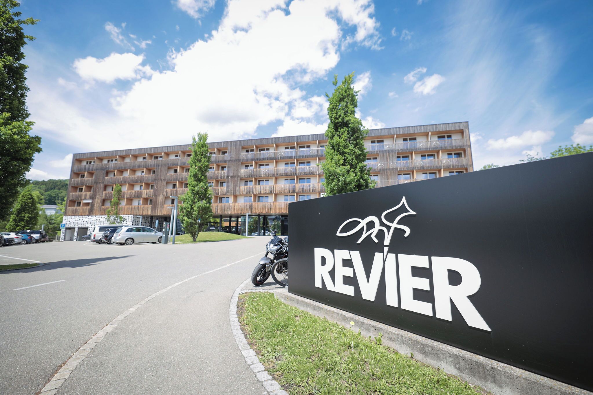 A building with a sign reading "REVIER" and a motorcycle parked in front.