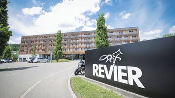 A building with a sign reading "REVIER" and a motorcycle parked in front.