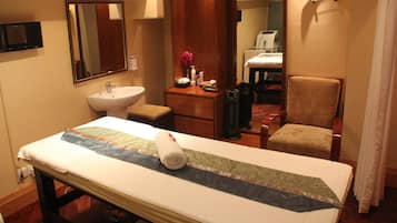 Cozy retreat with a neatly made bed, dresser, and comfortable seating area.