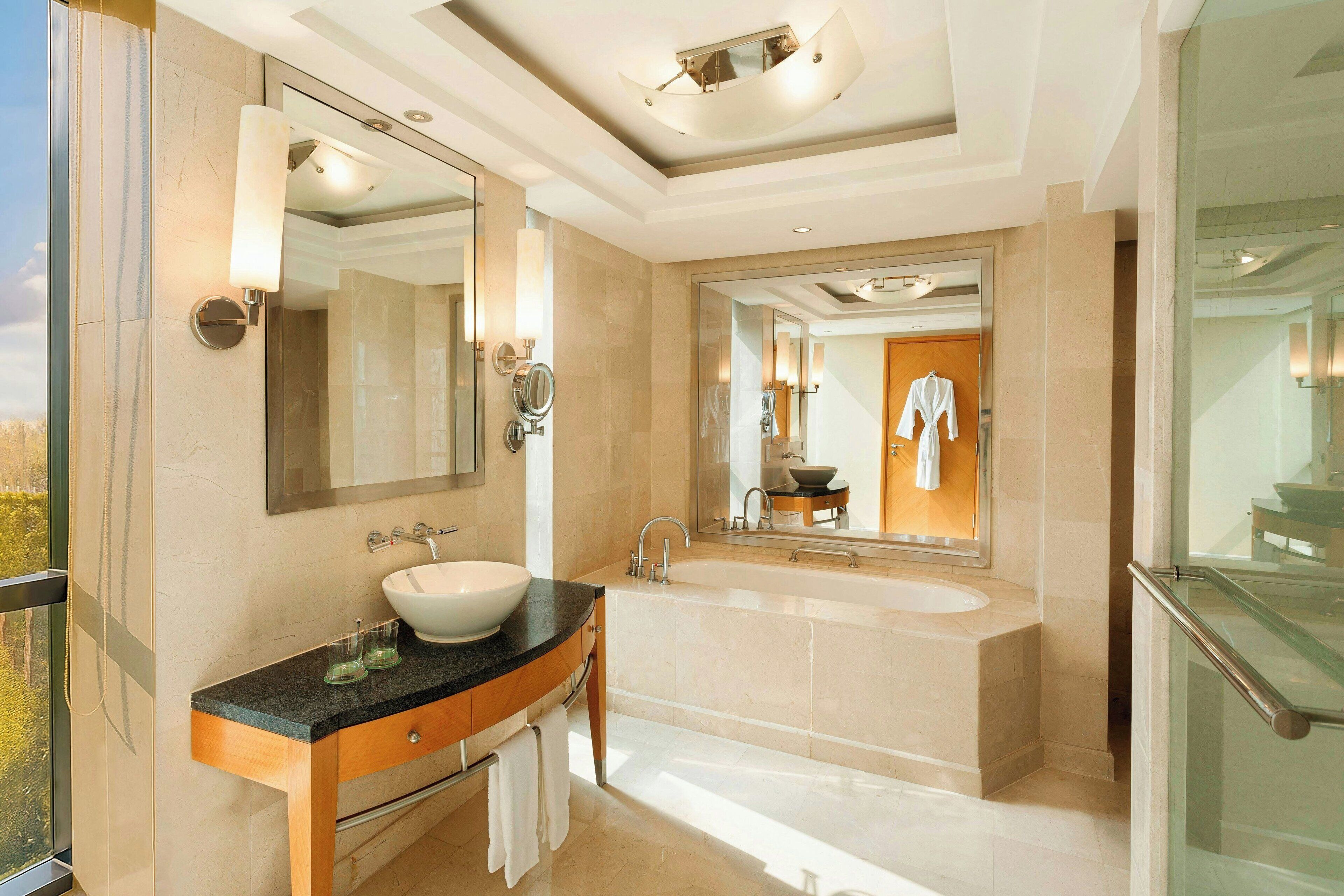 Une salle de bain moderne avec un grand lavabo, un miroir et une baignoire.