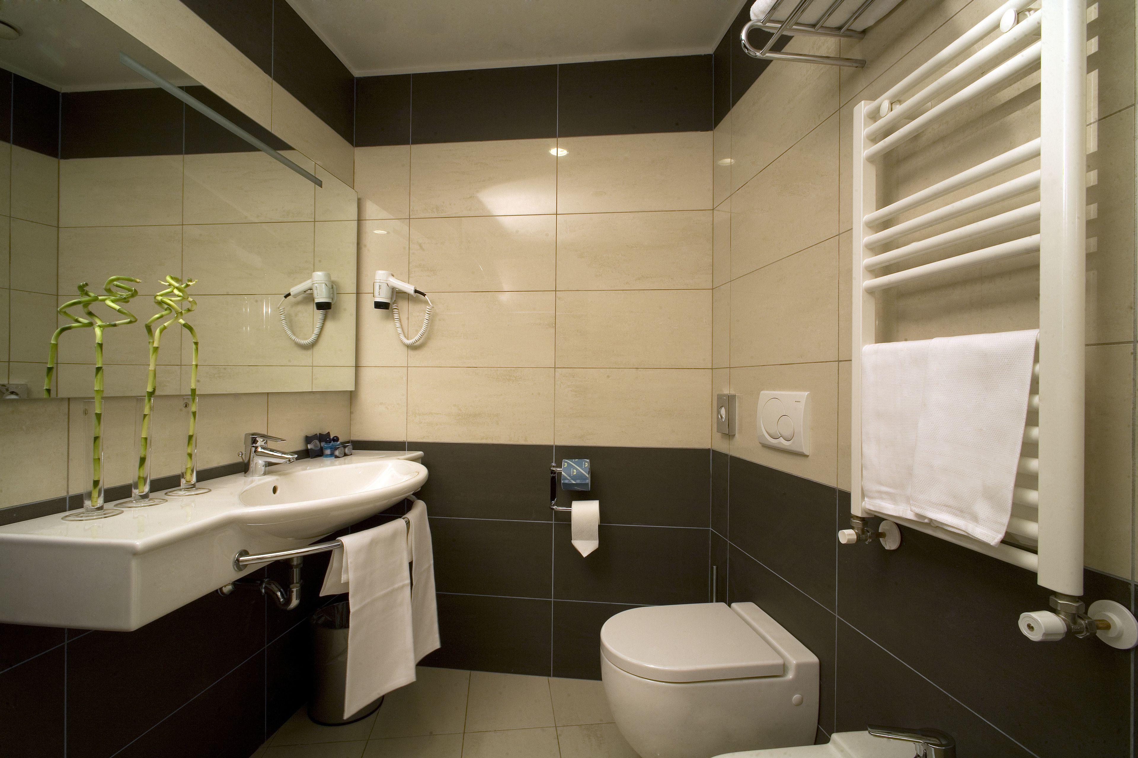 A modern bathroom with a sink, toilet, and towel rack.