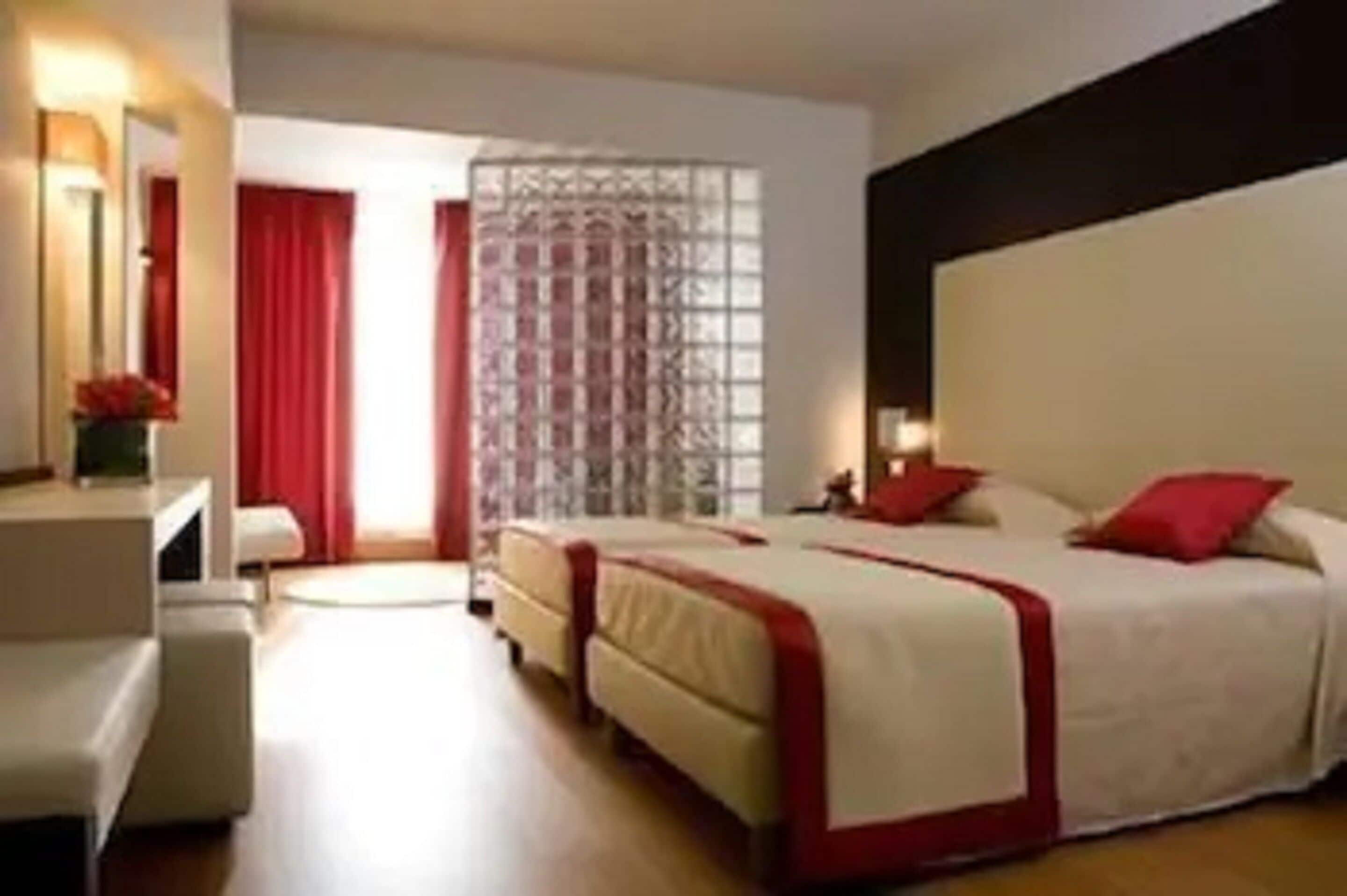 Une chambre d’hôtel avec un lit, un bureau et une chaise.
