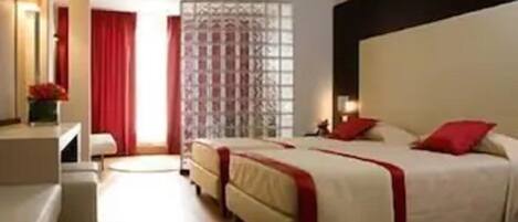 Una habitación de hotel con cama, escritorio y una silla.