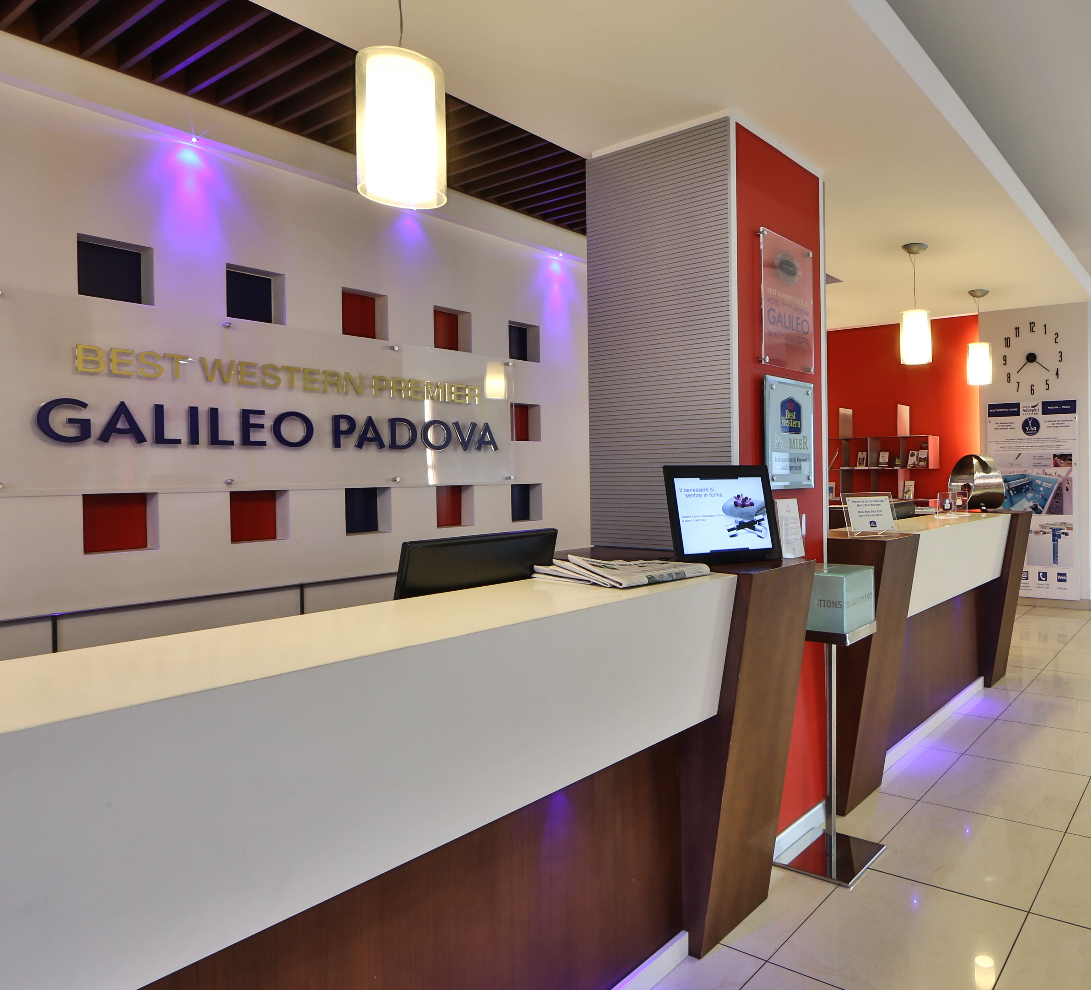 A hotel reception desk with a sign reading "BEST WESTERN PREMIER GALILEO PADOVA".
