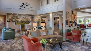 A spacious lobby with a high ceiling, multiple seating areas, and a reception desk. - La Quinta Inn & Suites by Wyndham Paso Robles (Paso Robles)