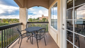 A balcony with a table and chairs, a view of a building with a flag, and a clear sky. - La Quinta Inn & Suites by Wyndham Paso Robles (Paso Robles)