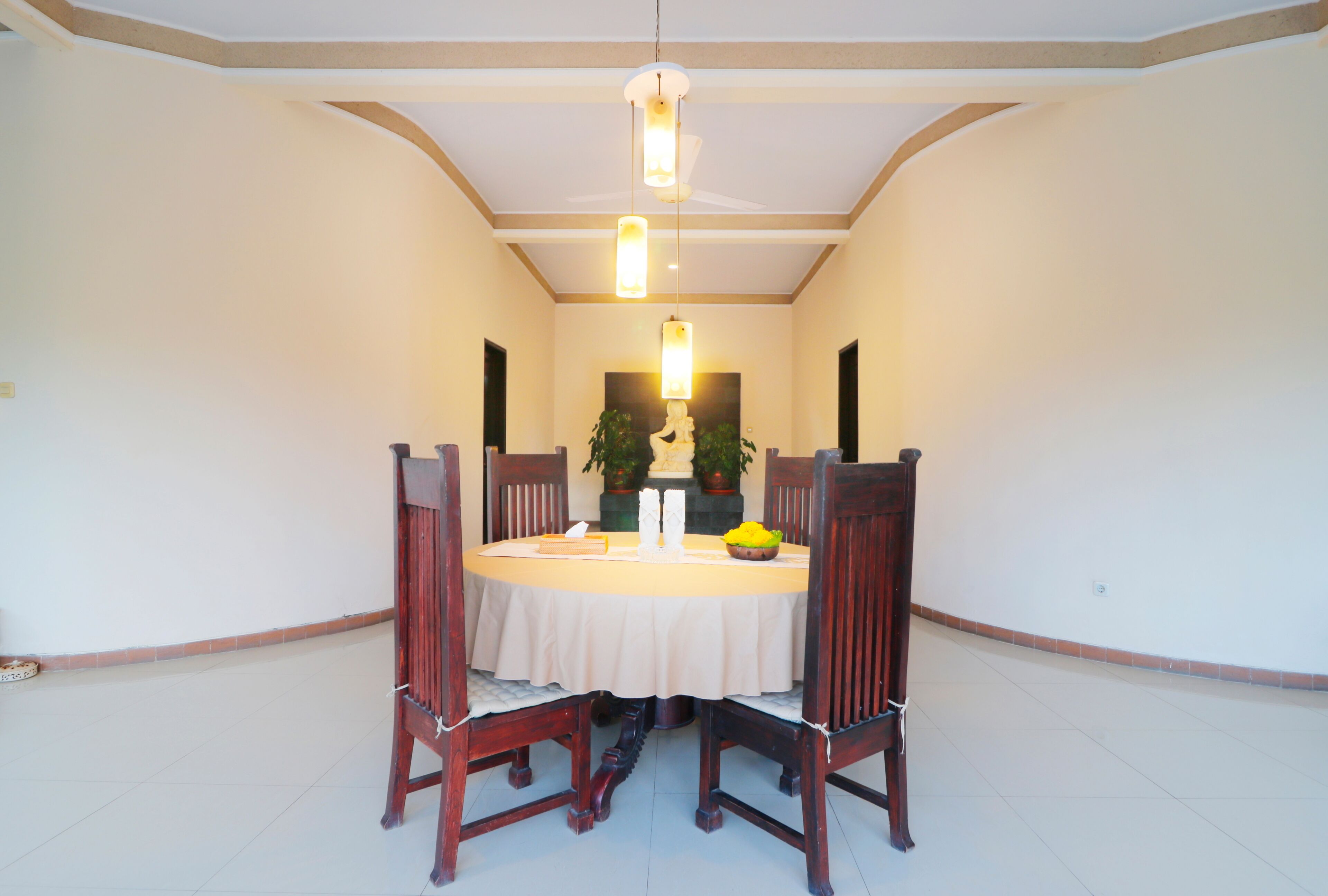 A dining area with a round table, chairs, and pendant lighting.
