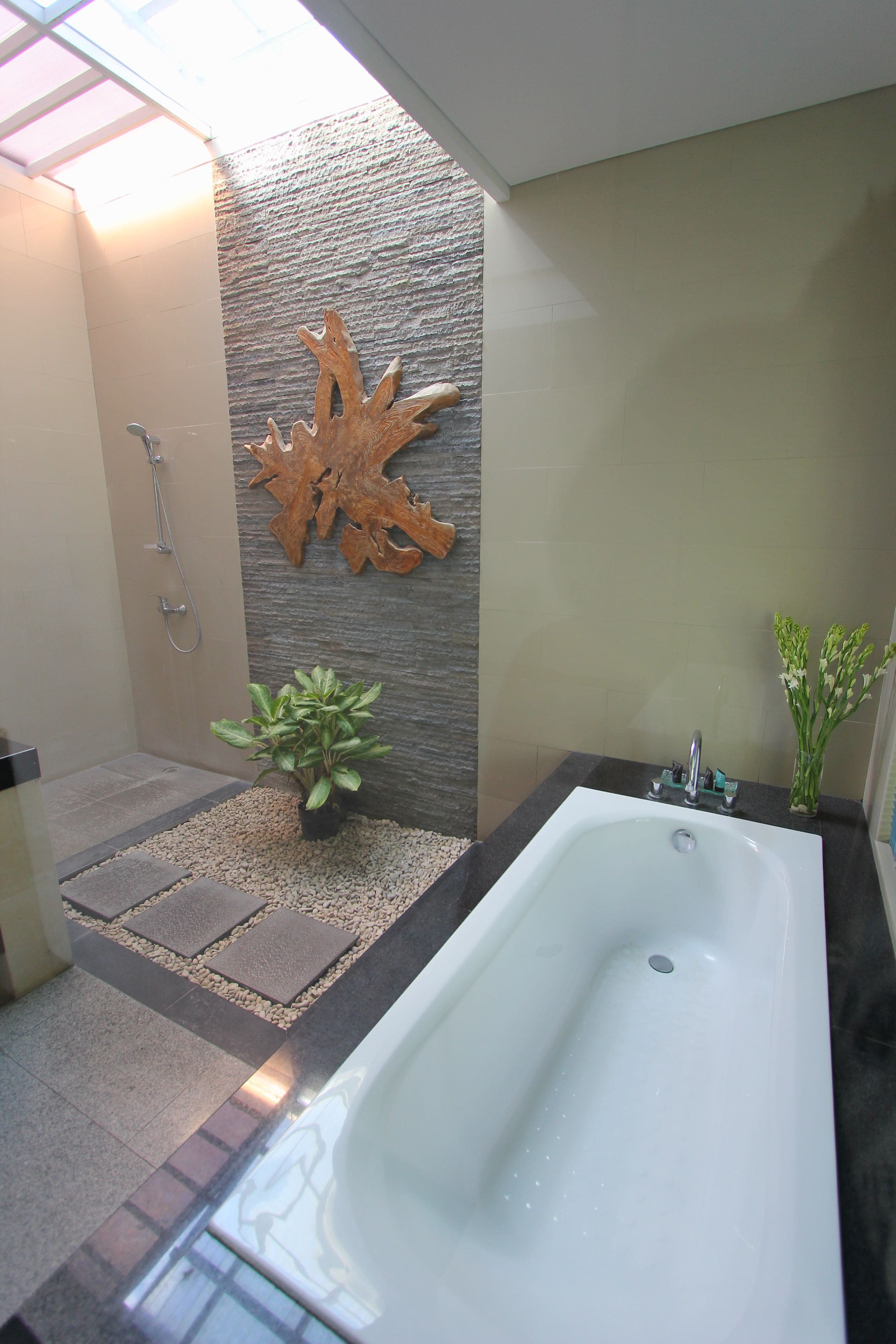 Une salle de bain moderne avec une grande baignoire, une douche et un mur décoratif.