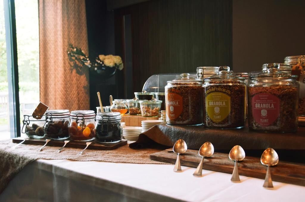 Un bufé de desayuno con diversas opciones de comida y tarros de granola.