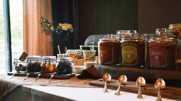 Un bufé de desayuno con diversas opciones de comida y tarros de granola.