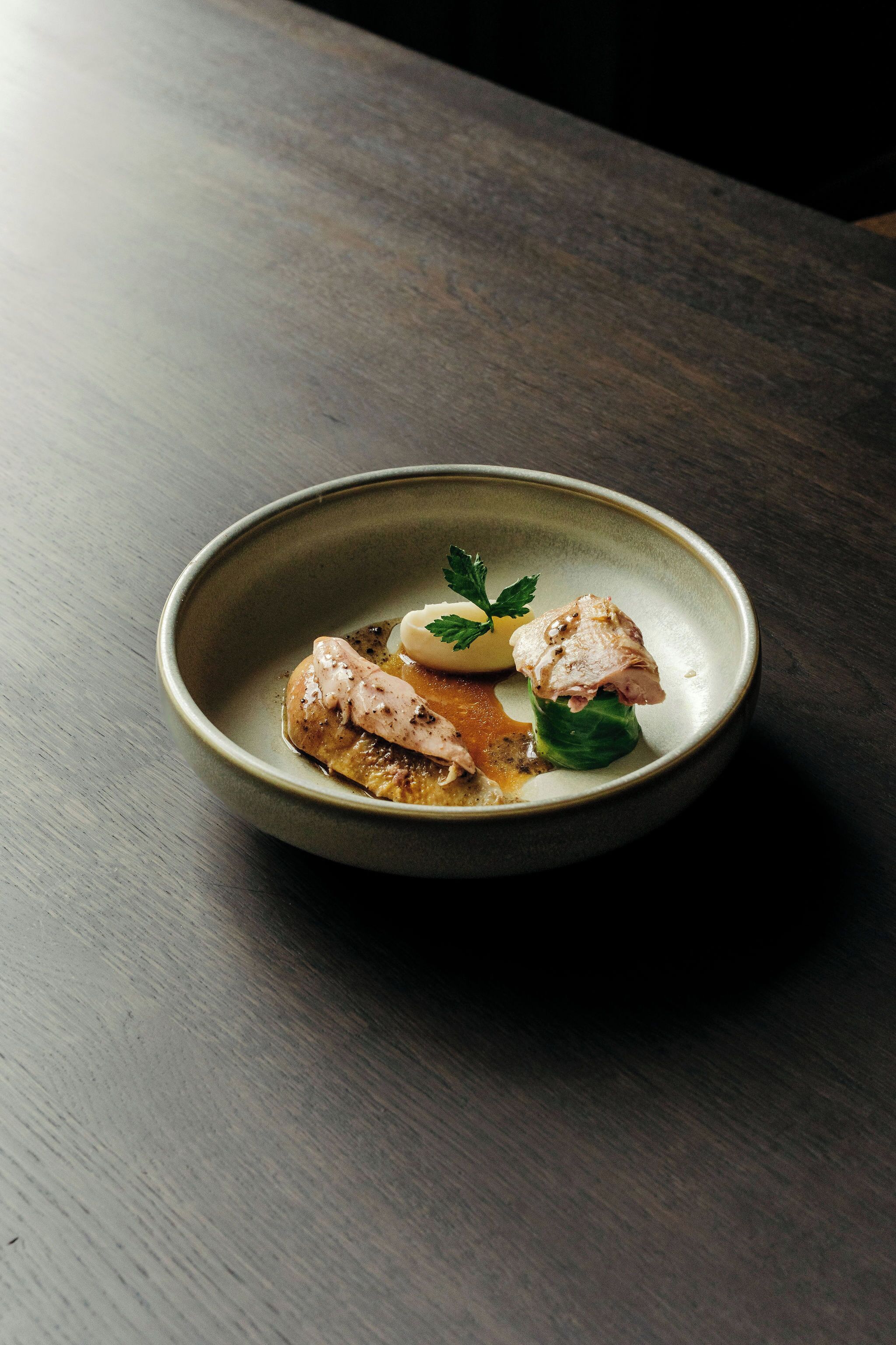 A bowl of food on a dark wooden table.