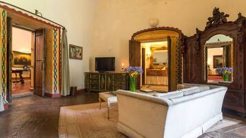 A living room with a sofa, a television, a cabinet, and a mirror.