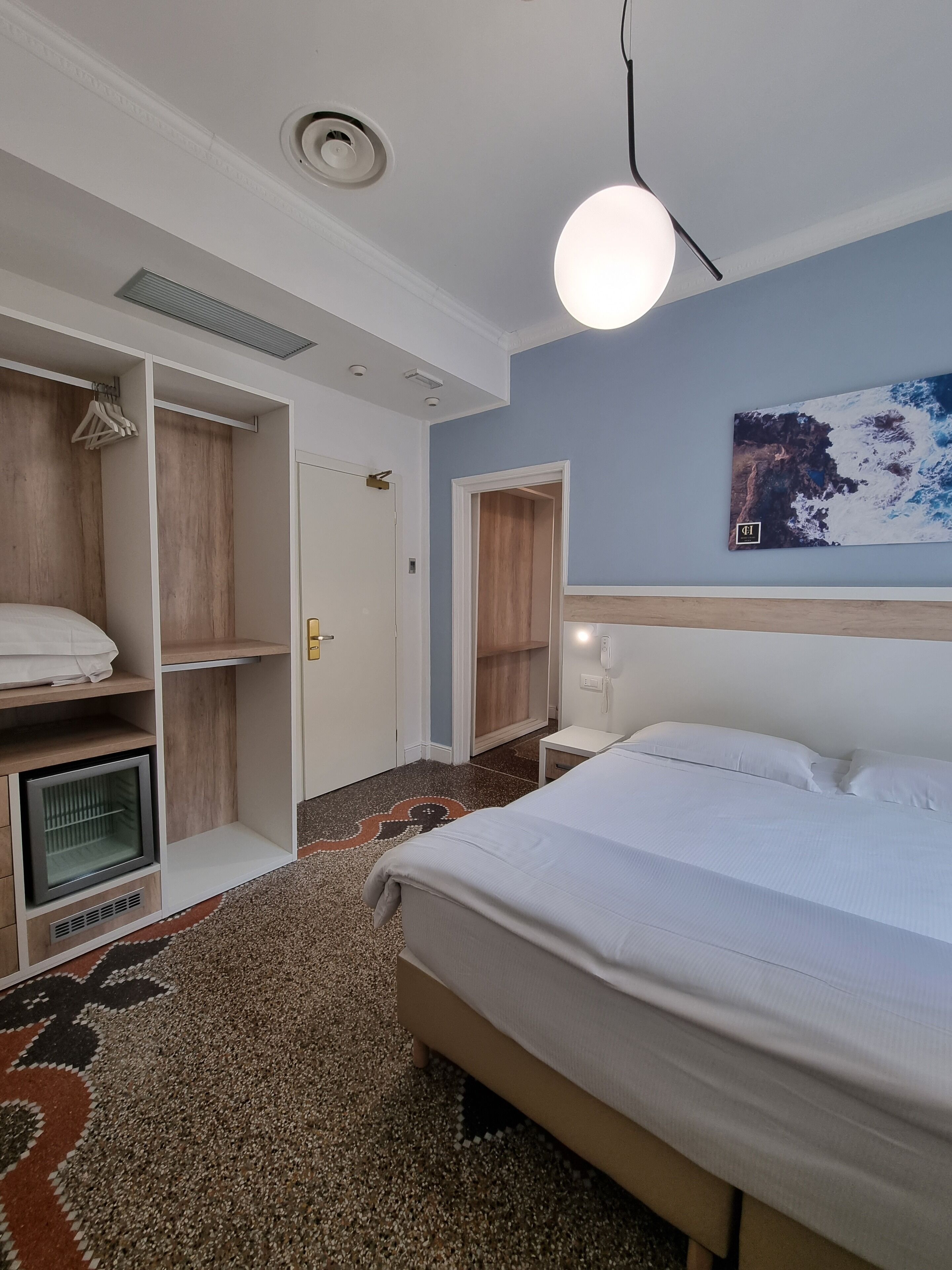 Una camera da letto con un letto, un armadio e un comodino.