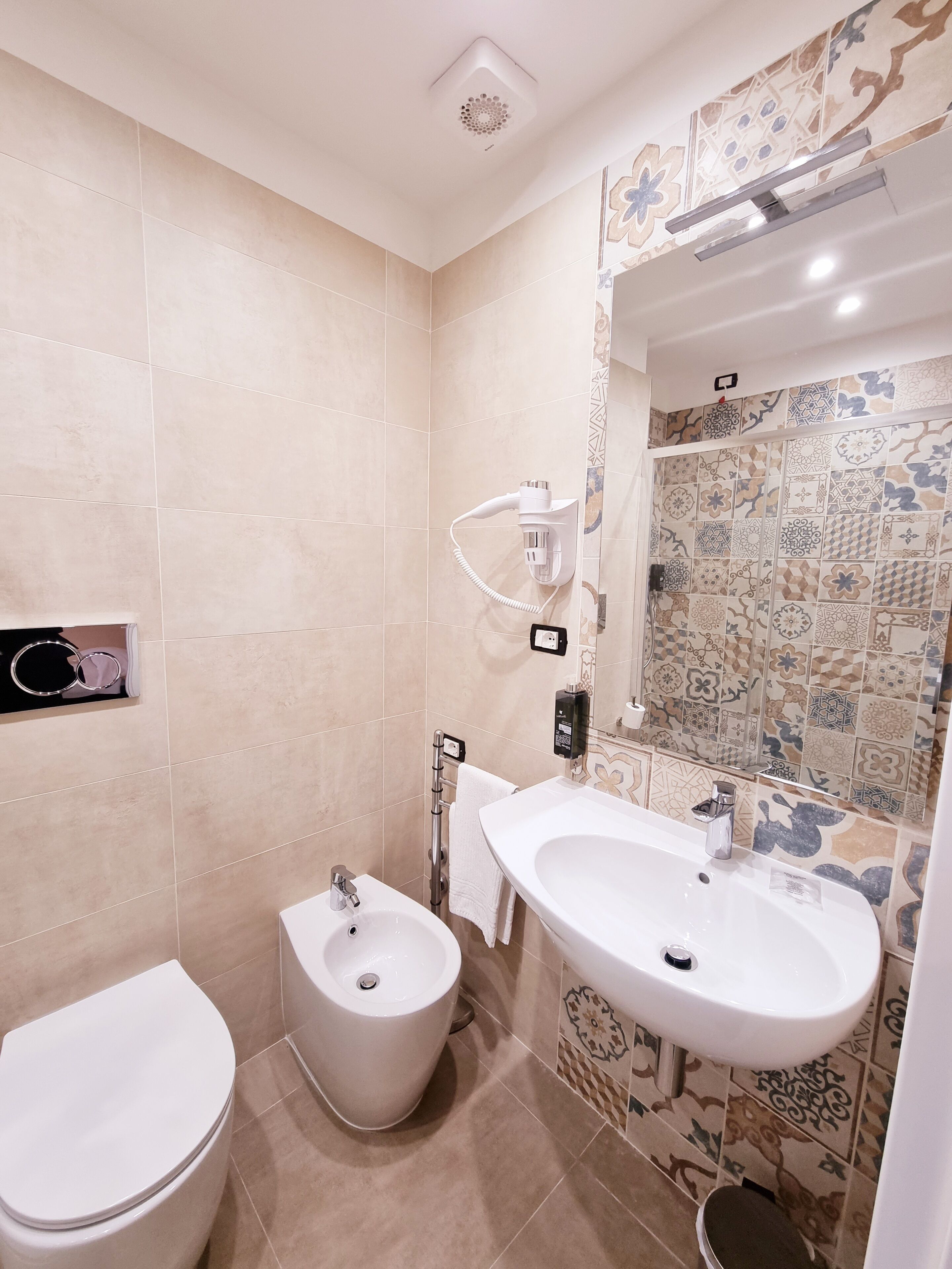 A bathroom with a bidet, a sink, and a toilet.