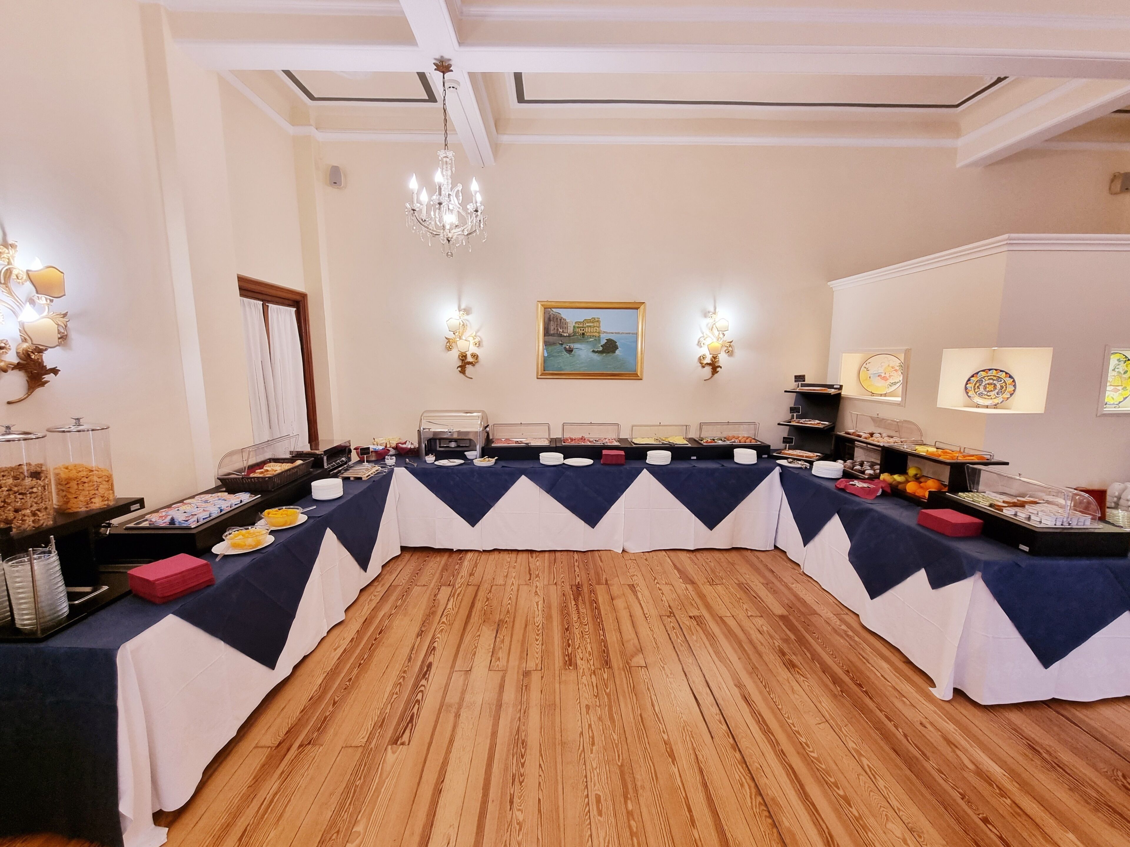 A buffet setup with various food items and a chandelier.