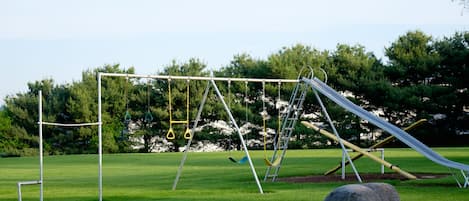 A playground with swings, a slide, and a climbing structure.