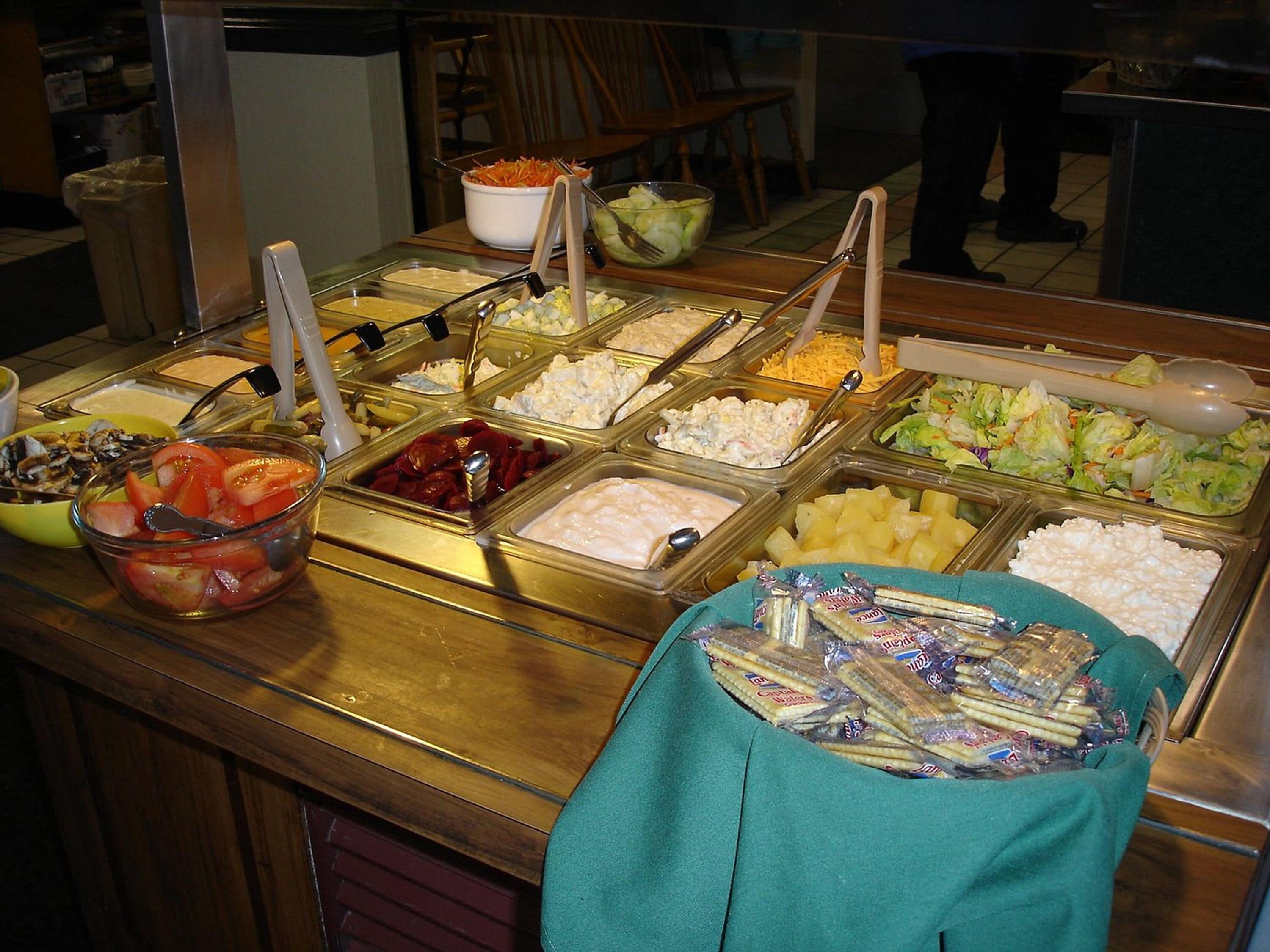 Un buffet proposant une variété de plats et d’ustensiles.