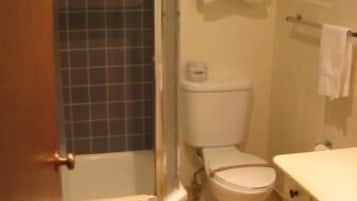 A bathroom with a shower, toilet, and sink.