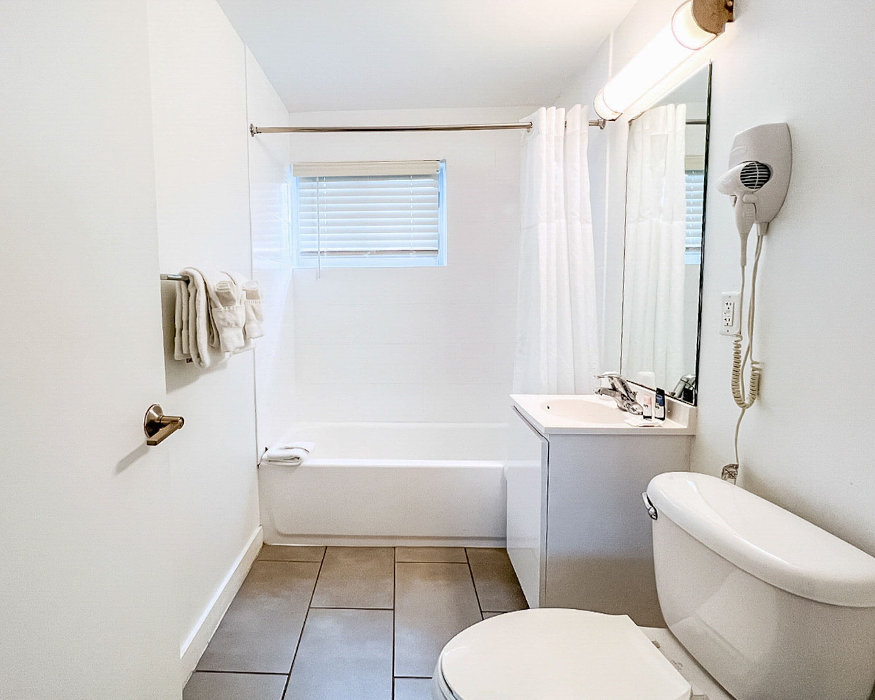 Une petite salle de bain comprenant une baignoire, des toilettes et un lavabo.