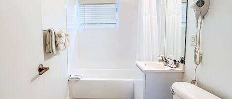 Une petite salle de bain comprenant une baignoire, des toilettes et un lavabo.