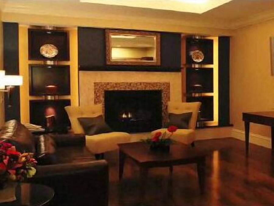 Una sala de estar con chimenea, un sofá, una mesa de centro y objetos decorativos.