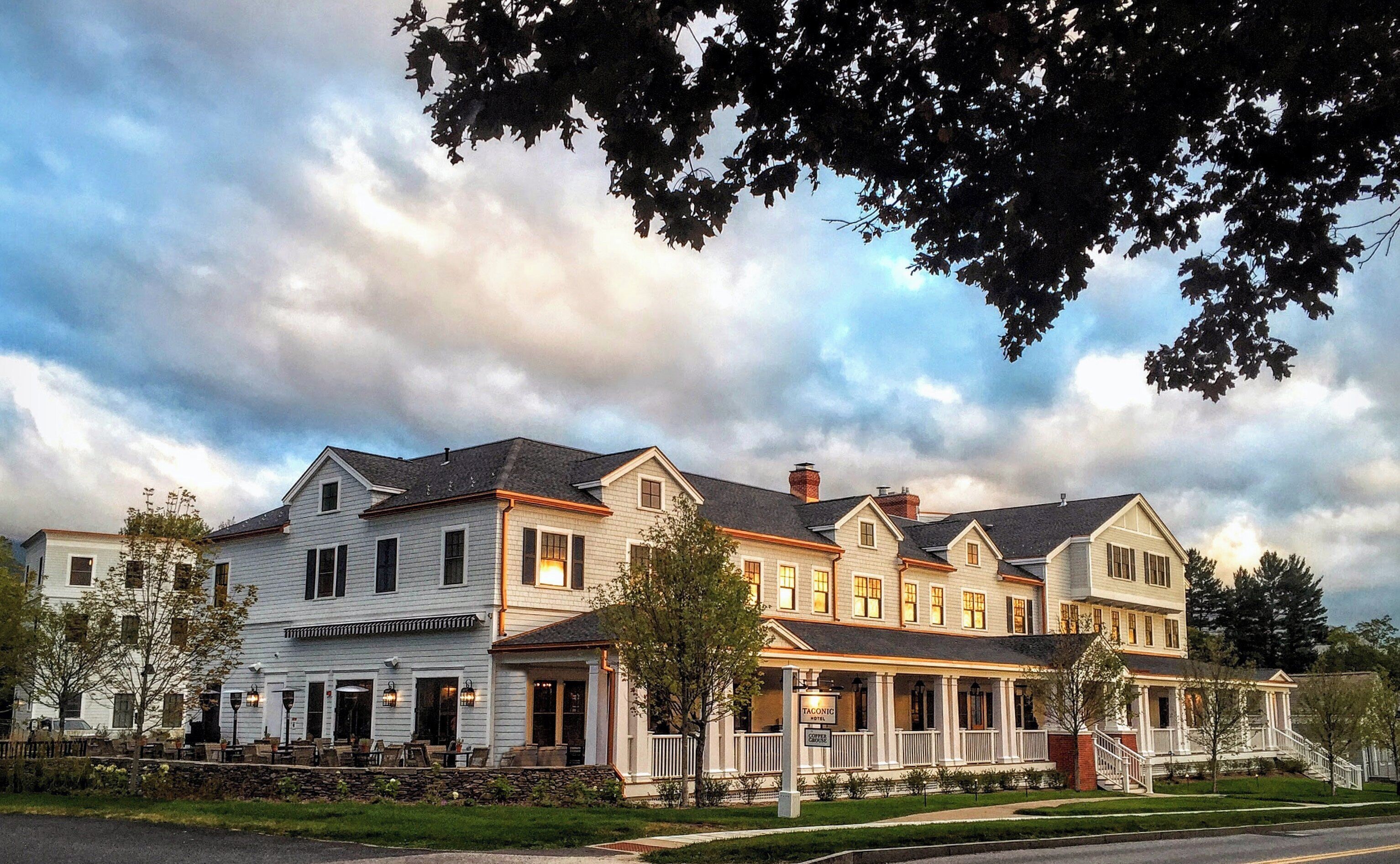 A large, multi-story hotel with a traditional architectural style, featuring a prominent front porch and multiple windows.