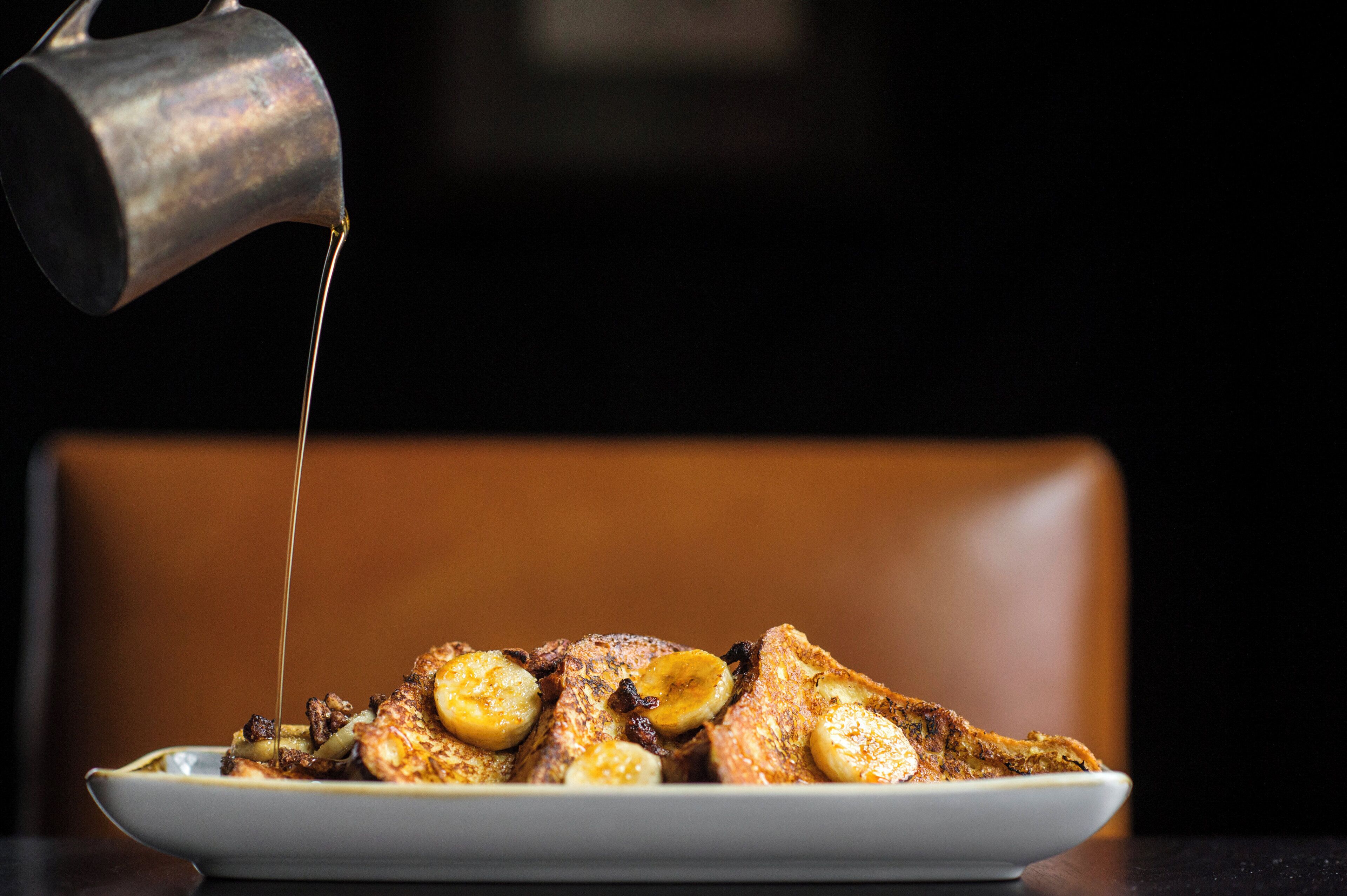 A plate of food with a sauce being poured over it.