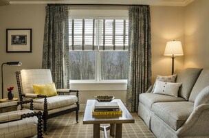 Una sala de estar con sofá, sillón y una mesa con libros.