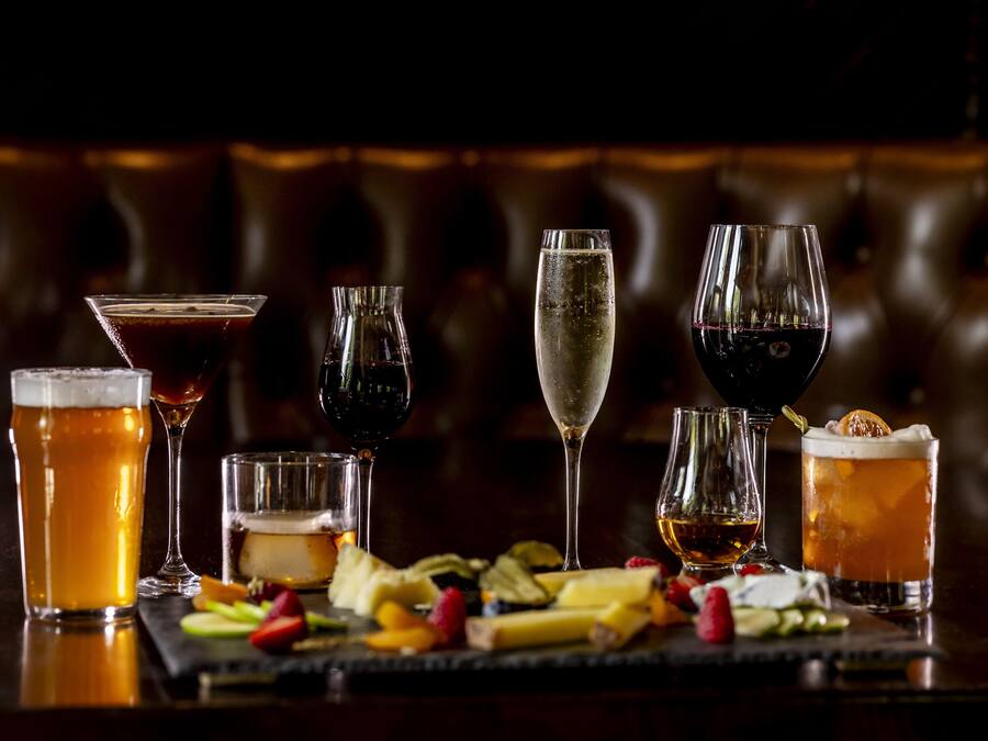 A selection of drinks and snacks on a bar counter.