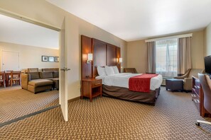 Una habitación de hotel con cama, sofá, escritorio y televisión.