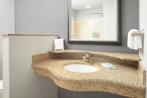 A bathroom with a granite countertop sink, a mirror, and a towel rack. - Courtyard Knoxville Airport Alcoa (Alcoa)