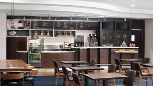 Een modern bistro met een toonbank, menukaarten en een zithoek.
