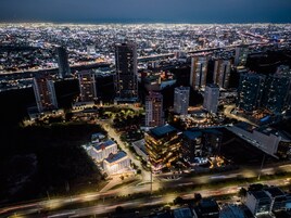 Vista aérea de un paisaje urbano nocturno con edificios e iluminadas calles.