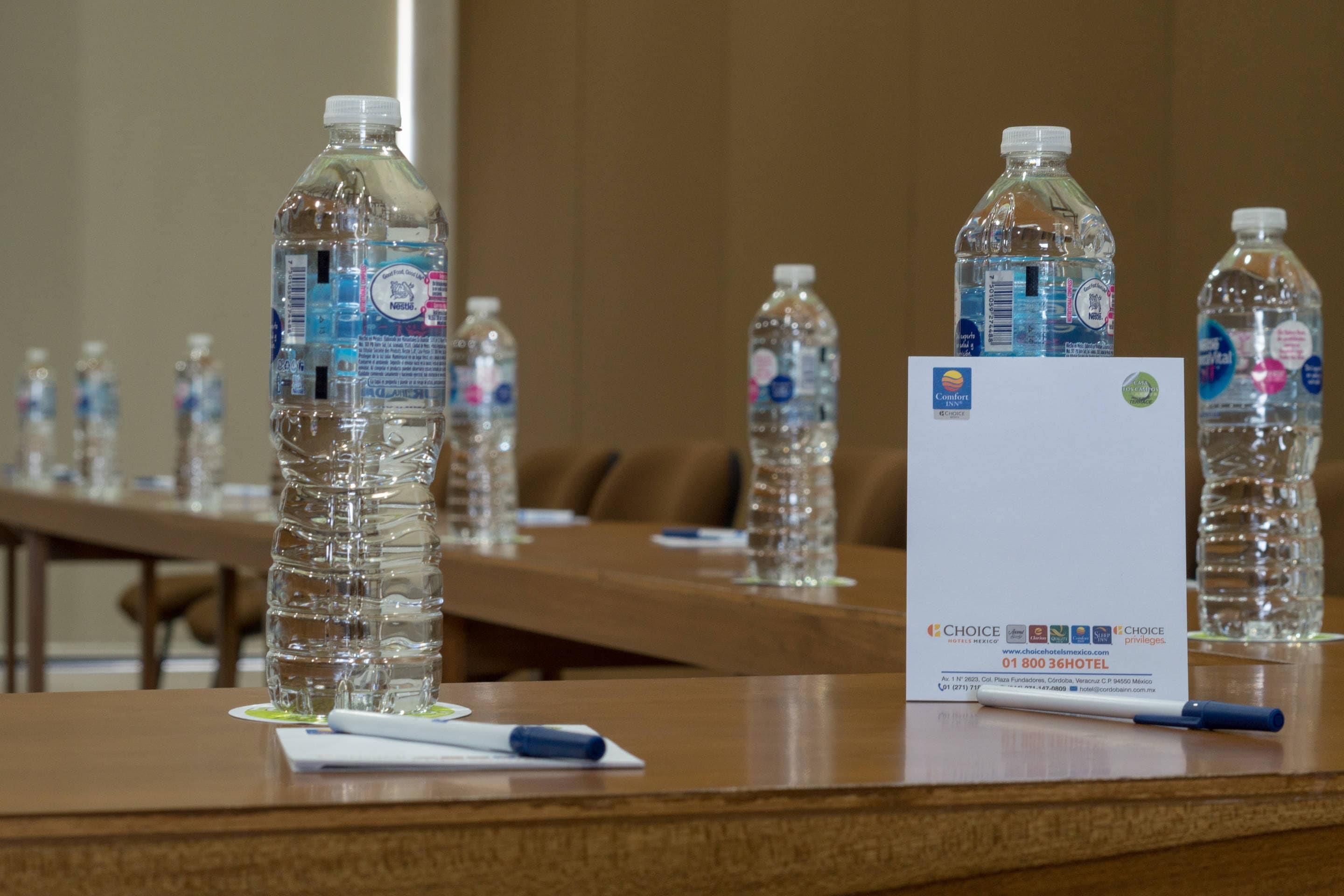 A conference table with water bottles and a business card.