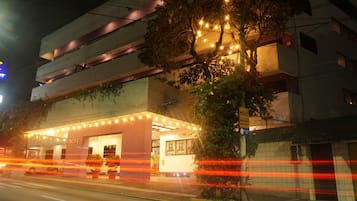 Un edificio con fachada plana, un árbol en frente y un letrero con el número 2623.