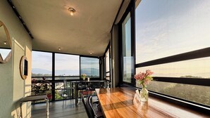A modern dining area with a wooden table, black chairs, and a view of the city through large windows. - Comfort Inn Cordoba (Córdoba)