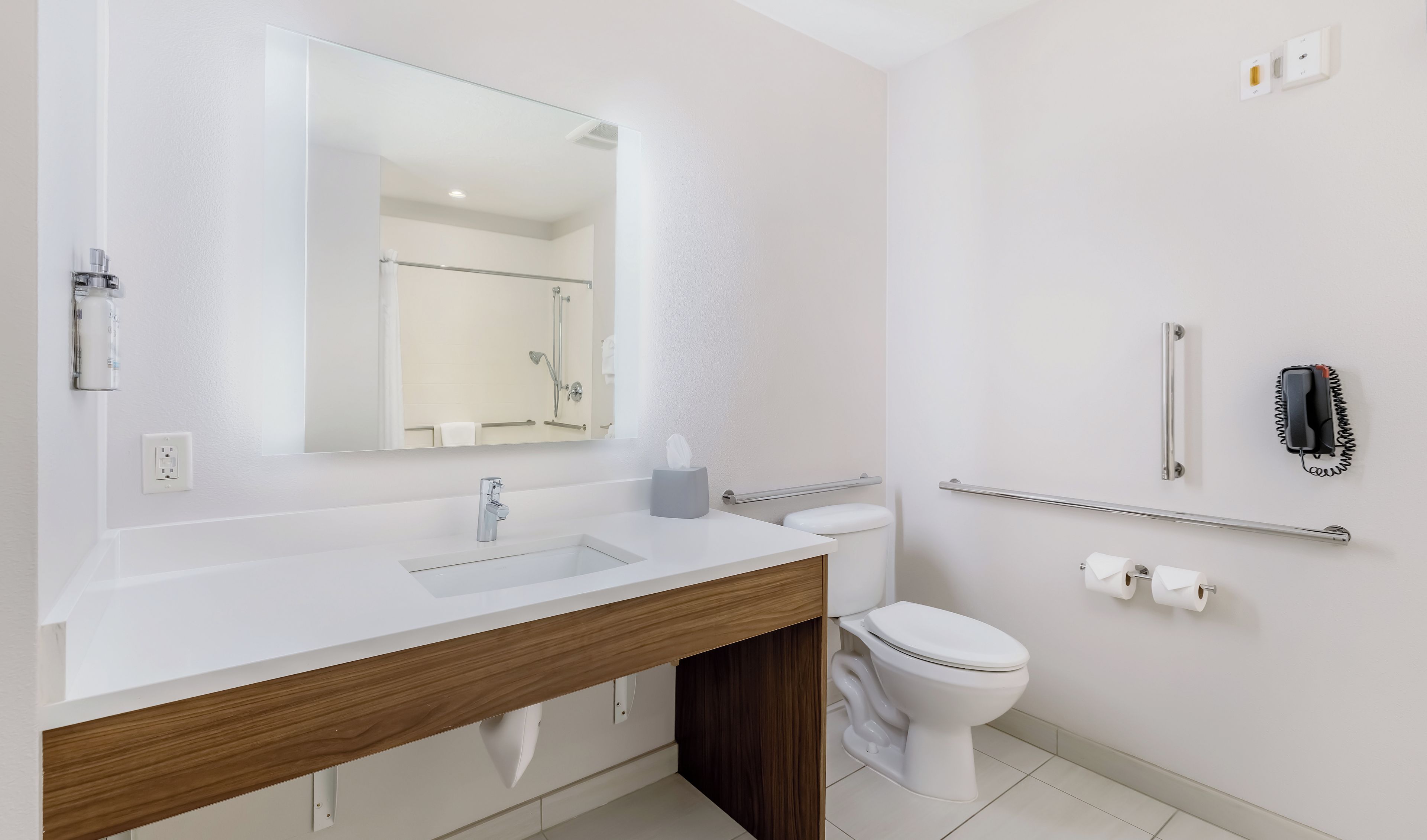 Ein modernes Badezimmer mit Waschbecken, Spiegel und Toilette in Weiß.
