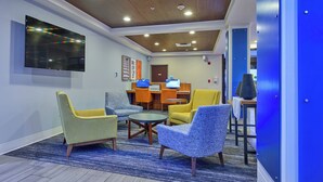 A lobby with seating, a reception desk, and a flat-screen TV.