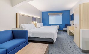 A hotel room with a bed, a blue sofa, a desk, and a wardrobe. - Holiday Inn Express & Suites Medford-Central Point (Central Point)