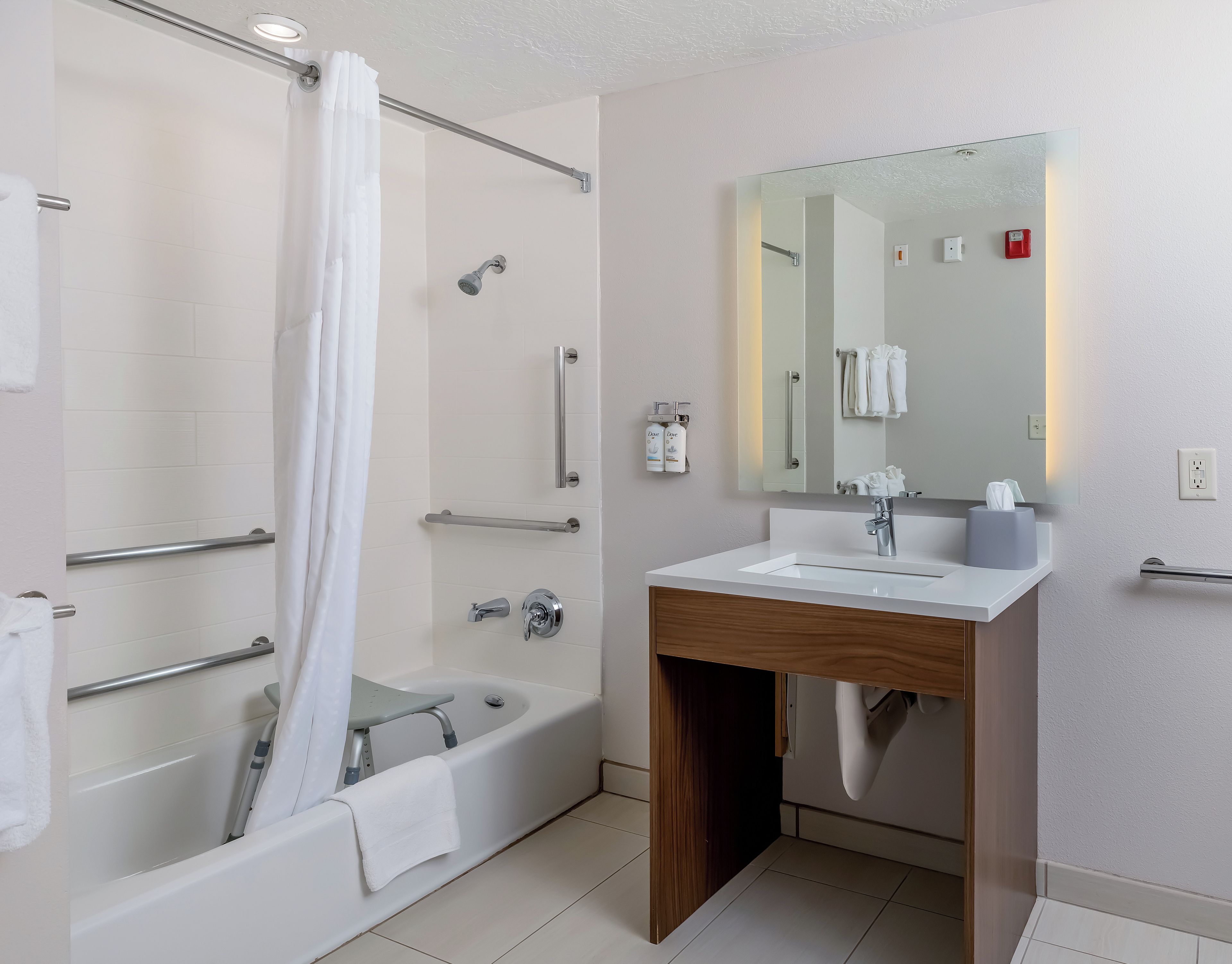 A modern bathroom with a bathtub, shower, and vanity.