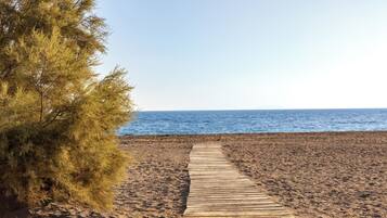 Walk along the straight boardwalk to the unadorned beach.