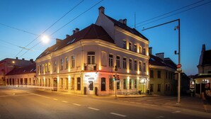 A historic building with a corner entrance, large windows, and a balcony. - City Hotels Rūdninkai (Vilnius)