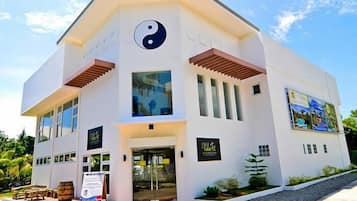 Stunning building with a unique yin-yang symbol on the facade, surrounded by a beautifully landscaped area.