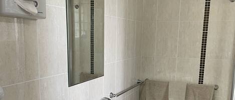 A bathroom with a white sink, a mirror, and a towel rack.
