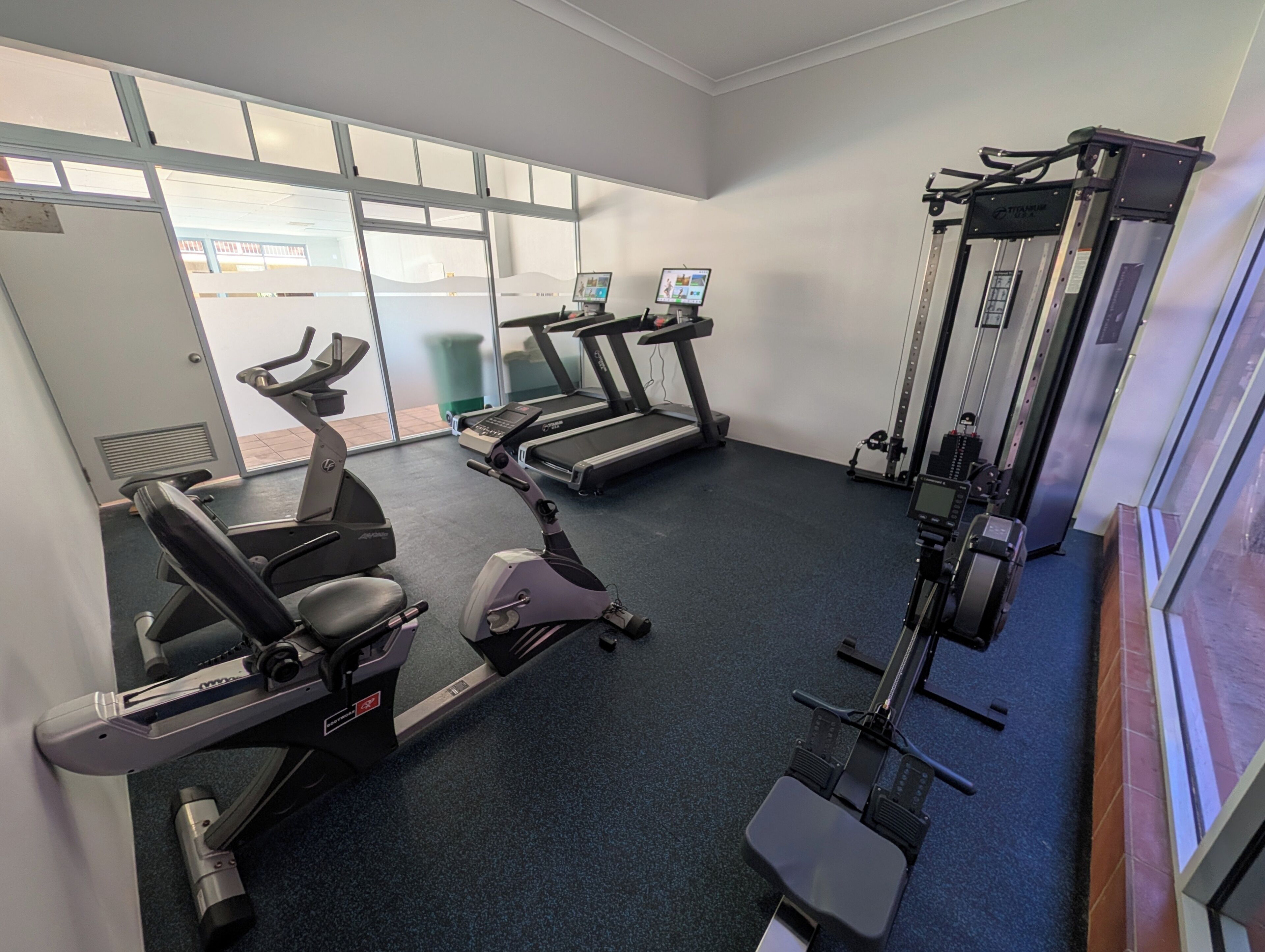 Un gimnasio con bicicletas estáticas, cintas de correr y máquinas de pesas.