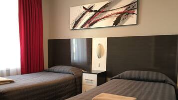 A hotel room with two beds, a nightstand, a mirror, and a painting on the wall.