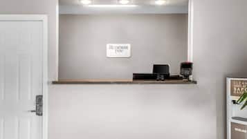 A reception desk with a sign for 'Rodeway Inn' and a digital payment terminal.