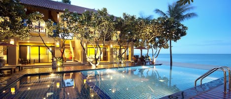 Een buitenzwembad, ligstoelen bij het zwembad