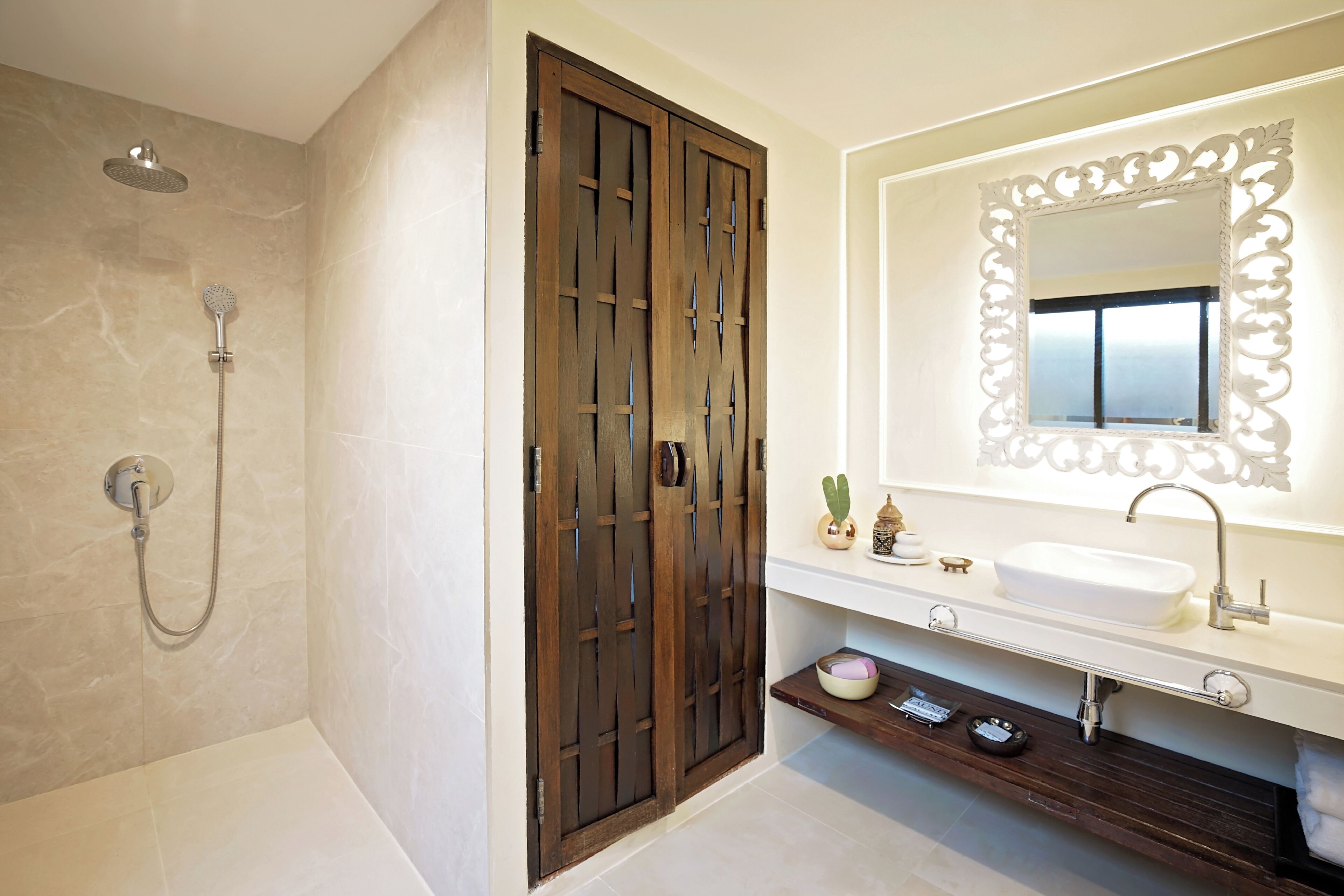 Un baño con ducha, un lavabo con un espejo decorativo y un tocador con estante.
