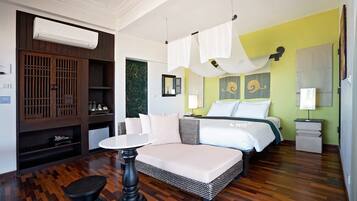 Una habitación de hotel con cama, mesitas de noche, una pequeña mesa, armario y aire acondicionado.